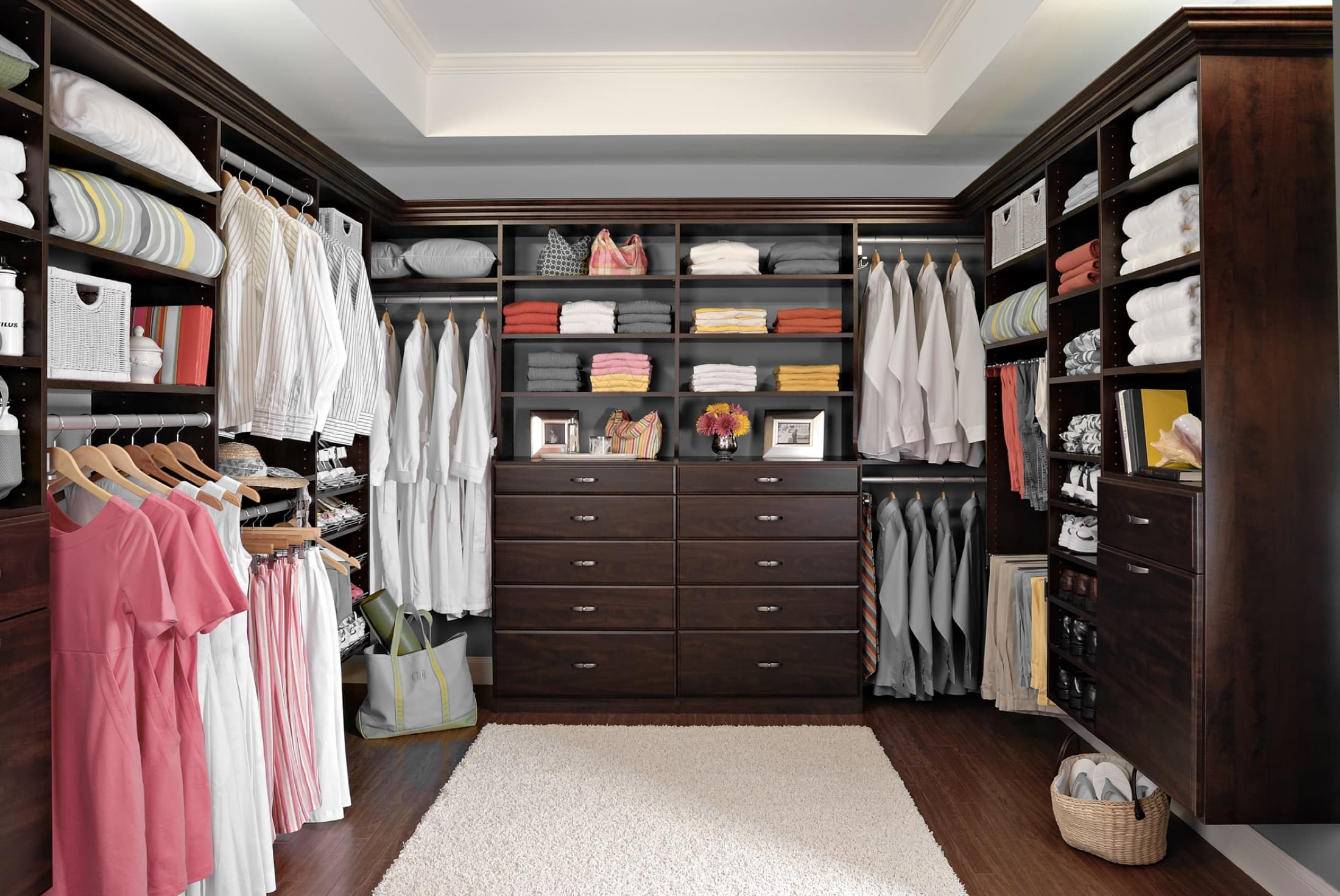 Spacious walk-in closet with natural wood floor and tailored shelving