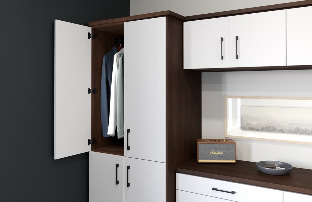 Wardrobe cabinet open to hanging space beside a dresser